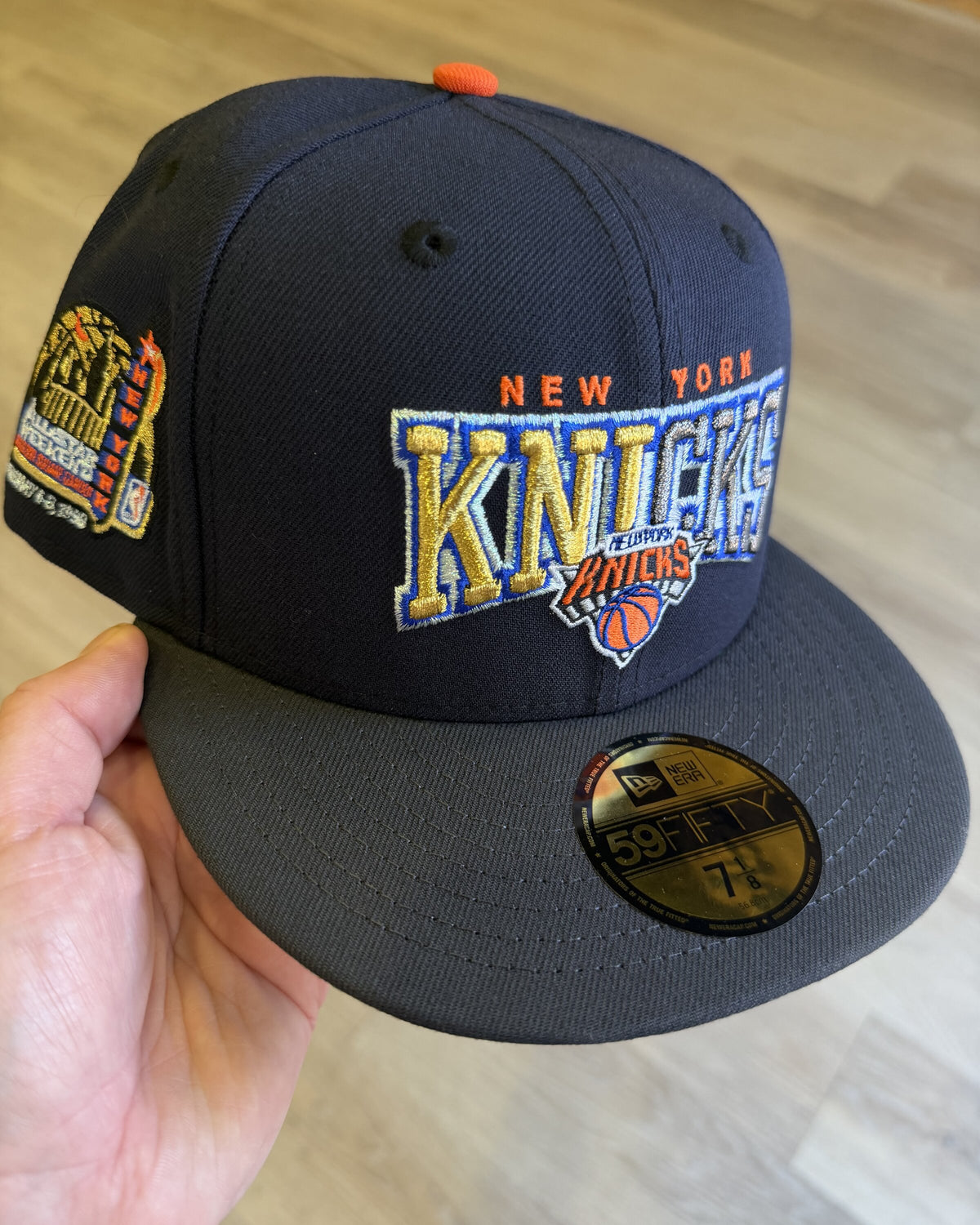 New York Knicks 1998 All Star Weekend 59Fifty, three quarter view of the navy crown with gold and blue Knicks script and the 1998 All Star Weekend side patch